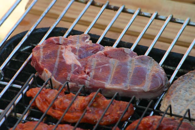 Food Beef steak that has just started cooking on a gas barbecue