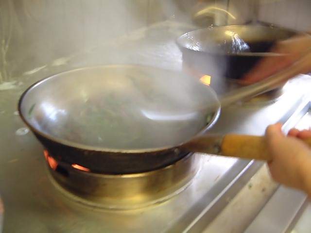 Food Chinese cooking in a fiery wok