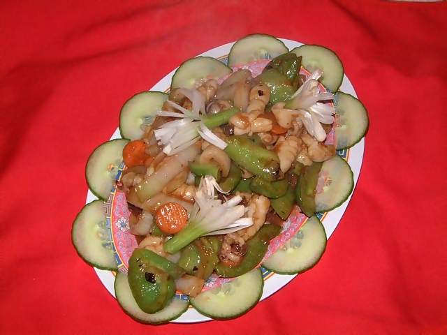 Food Chinese meal of squid in black bean sauce with green pepper and onions garnished with sping onions