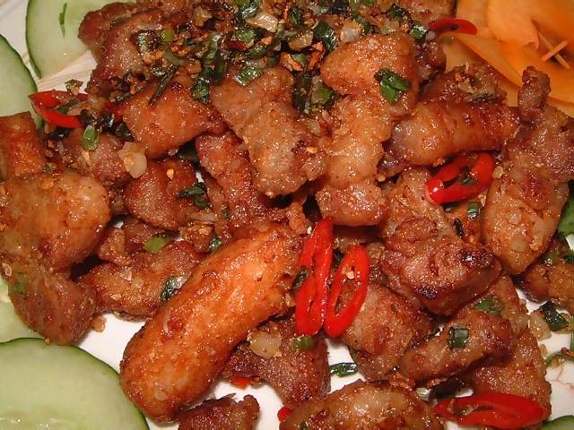 Food Closeup chinese meal of salt and pepper pork with chillies garnished with cucumber