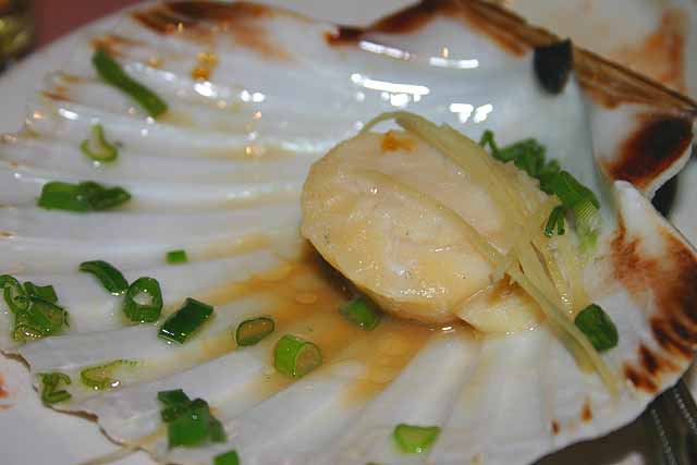Food Closeup of scallop in its shell in a Chinese banquet