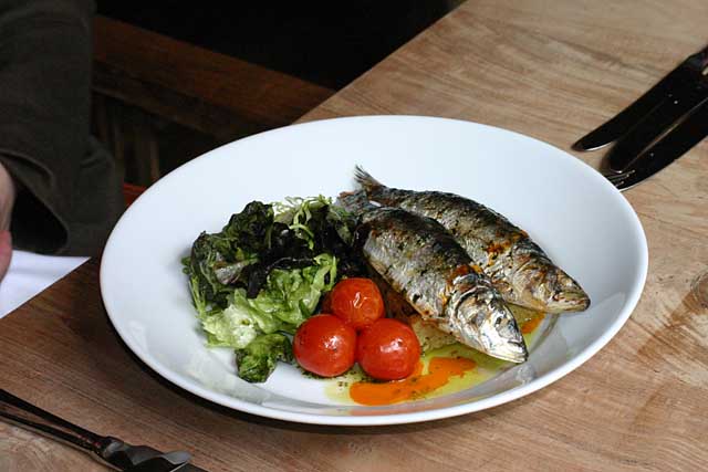 Food Photo of two grilled sardines and three cherry tomatoes