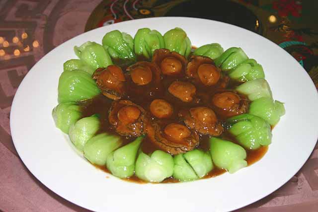 Food Plate of whole Abalone surrounded by Pak Choi Hearts