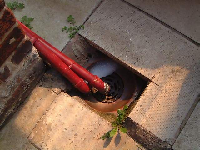 Household Grid and drain with red drainpipe
