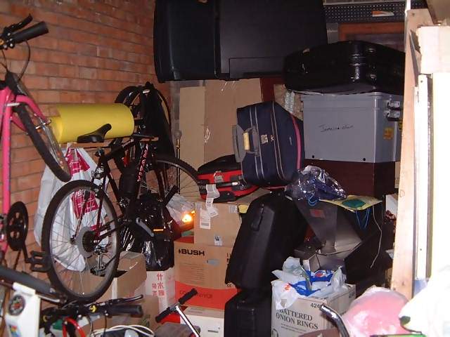 Household Junk in garage including bikes and suitcases