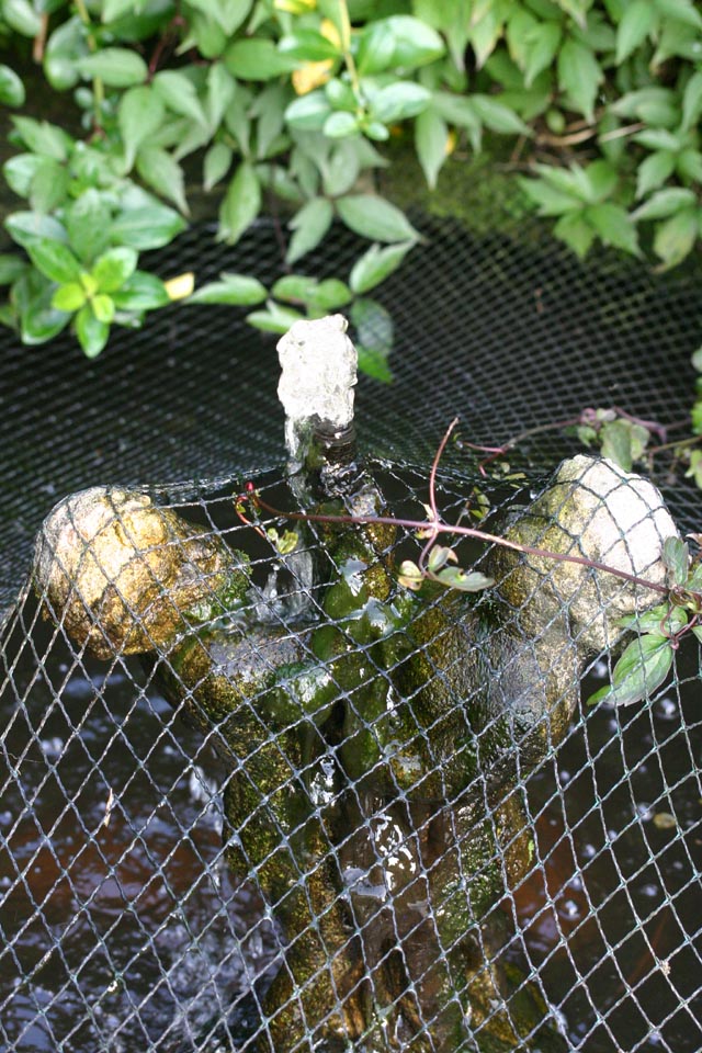 Water Wider view of gurgling stone garden fountain